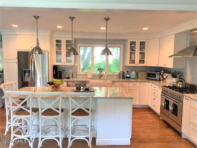 8 Perry Place Riverside, CT 06878 - Photo 4 of 26 a kitchen with stainless steel appliances granite countertop a stove and white cabinets