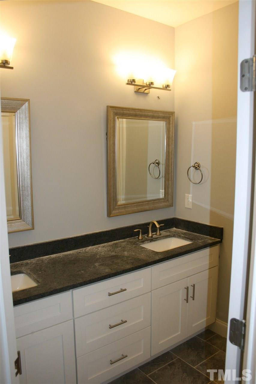 8703 Duckview Court Raleigh, NC 27613 - Photo 15 of 16 a bathroom with a granite countertop sink and a mirror