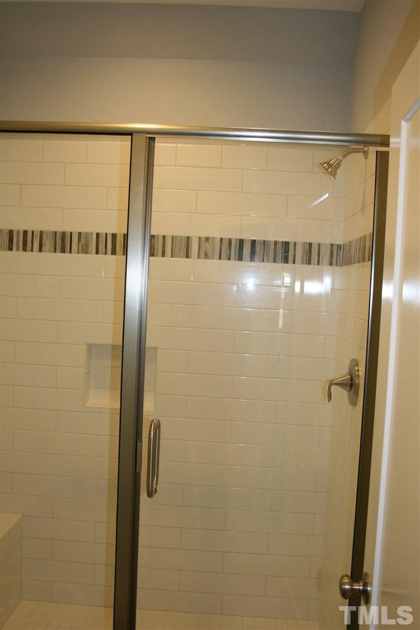 8703 Duckview Court Raleigh, NC 27613 - Photo 16 of 16 a bathroom with a glass shower door