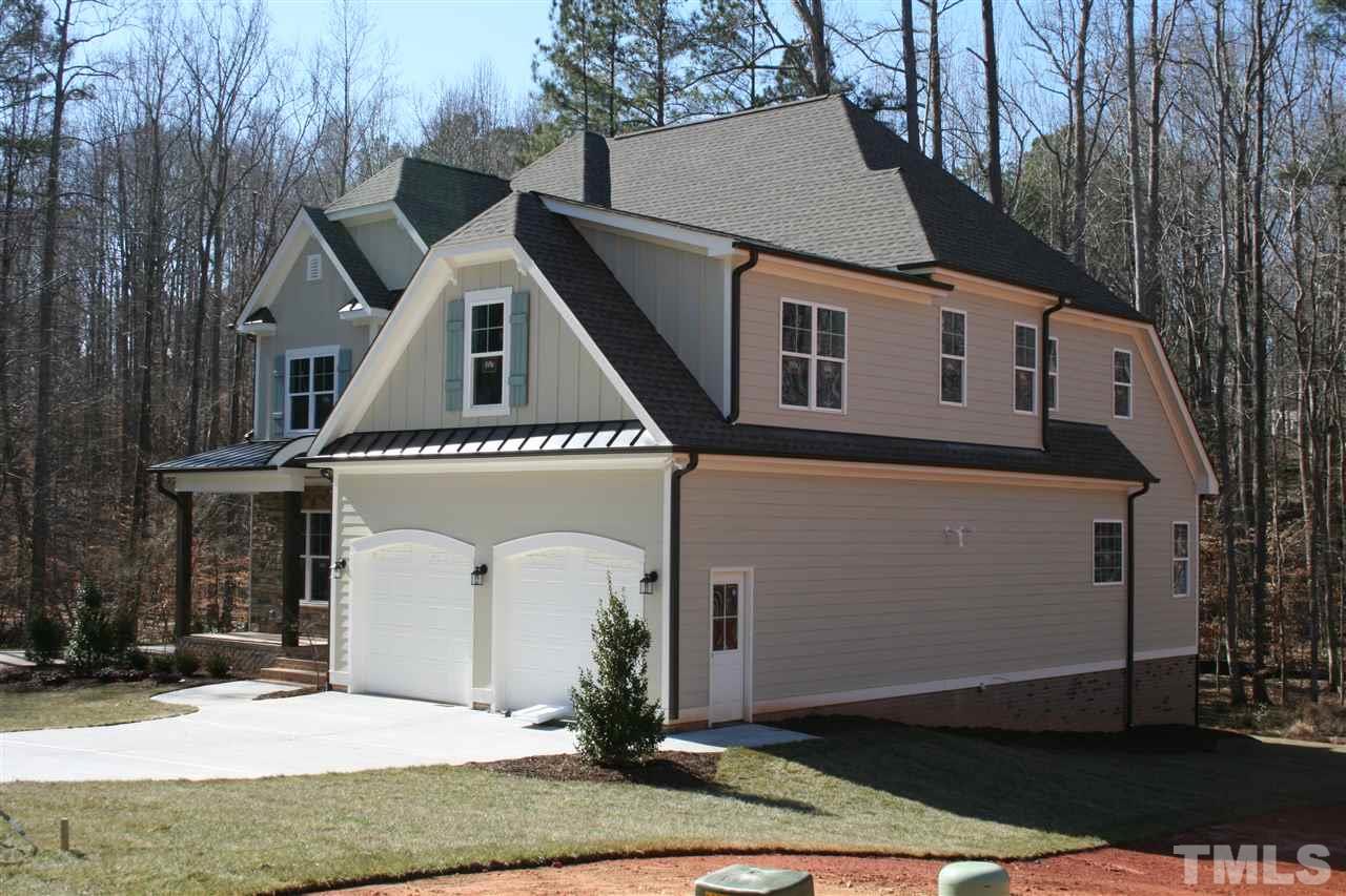 8703 Duckview Court Raleigh, NC 27613 - Photo 3 of 16 a view of a white house with large windows and a small yard