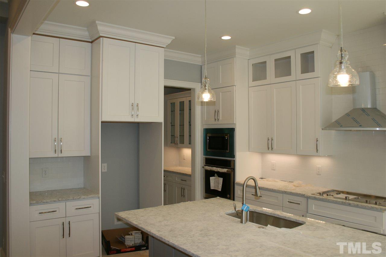 8703 Duckview Court Raleigh, NC 27613 - Photo 4 of 16 a kitchen with white cabinets and appliances