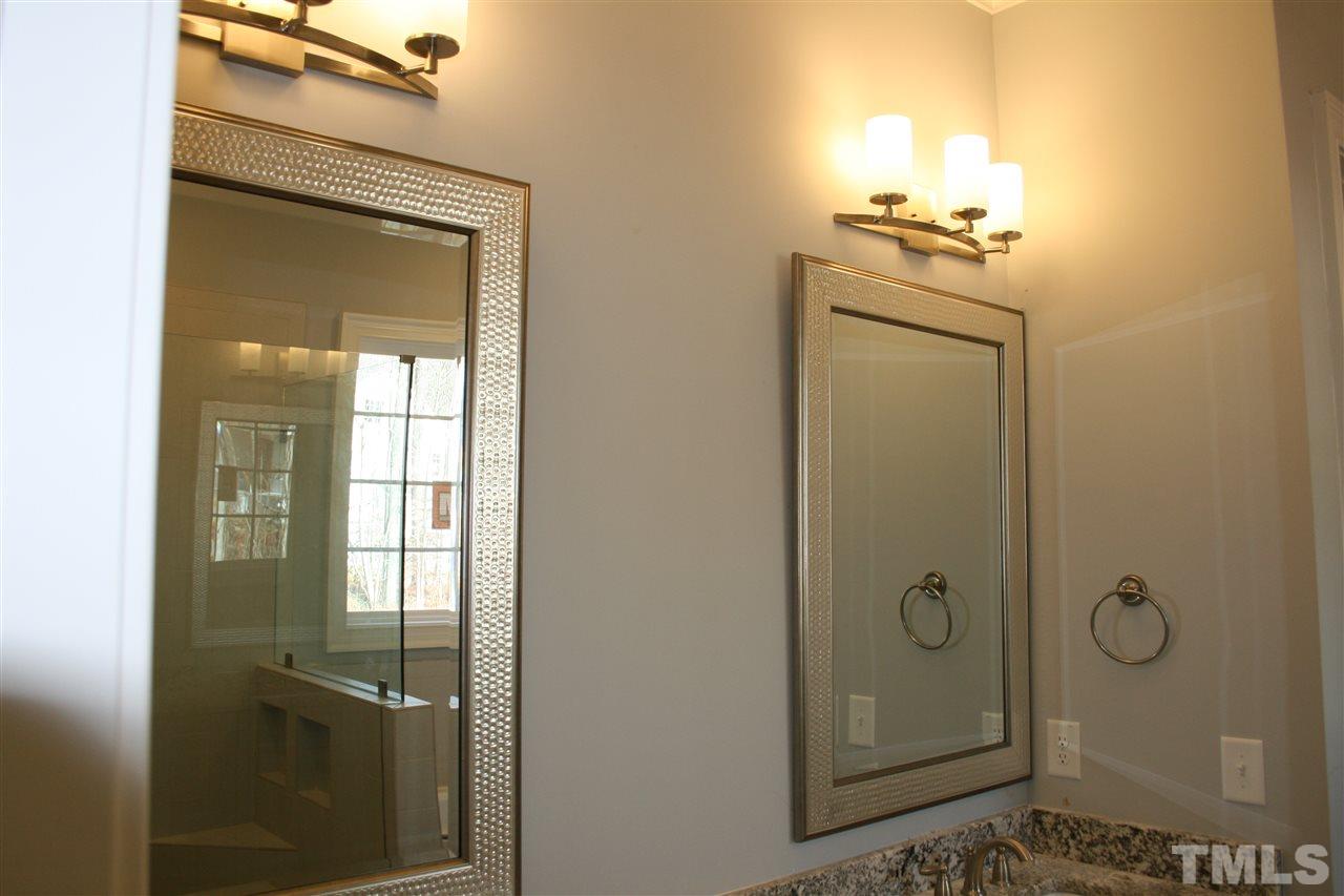 8703 Duckview Court Raleigh, NC 27613 - Photo 8 of 16 a bathroom with a shower a mirror and a sink