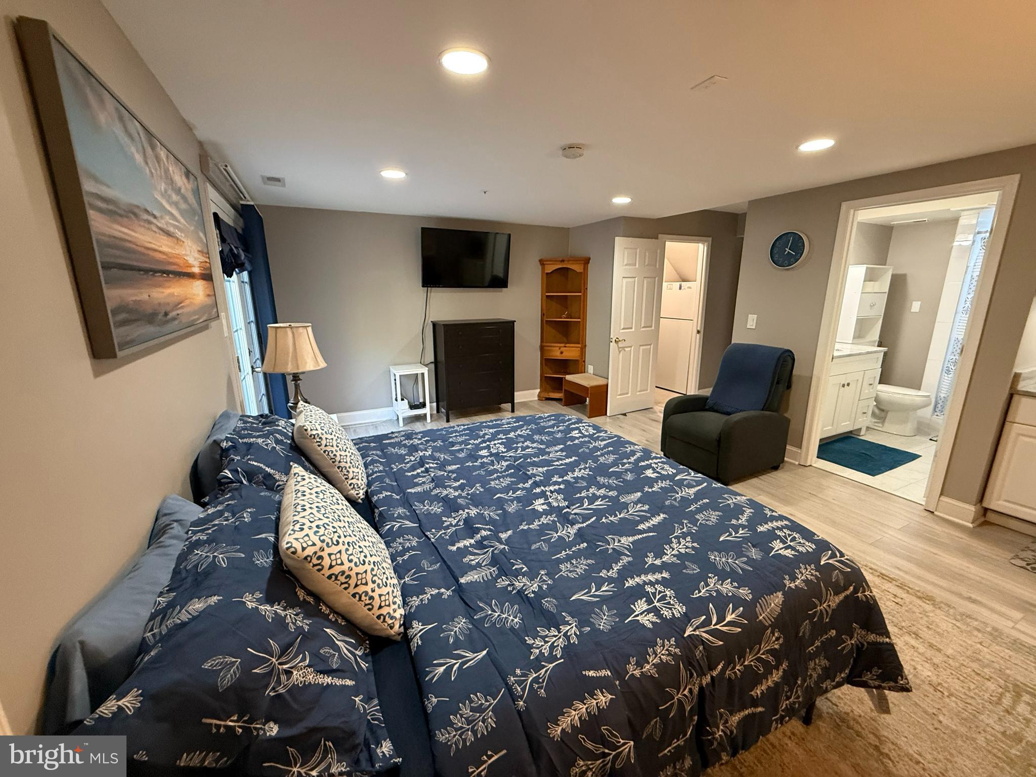 a bedroom with a bed large mirror and a flat screen tv