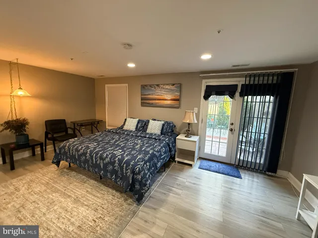 a spacious bedroom with a balcony a bed and a table in it