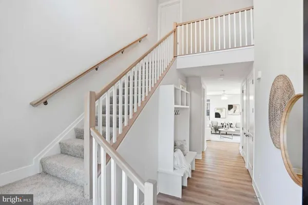 a view of a hallway with wooden floor and stairs