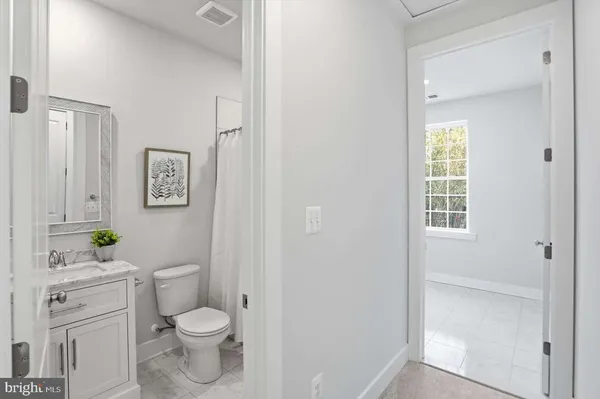 a bathroom with a granite countertop toilet a sink and a window