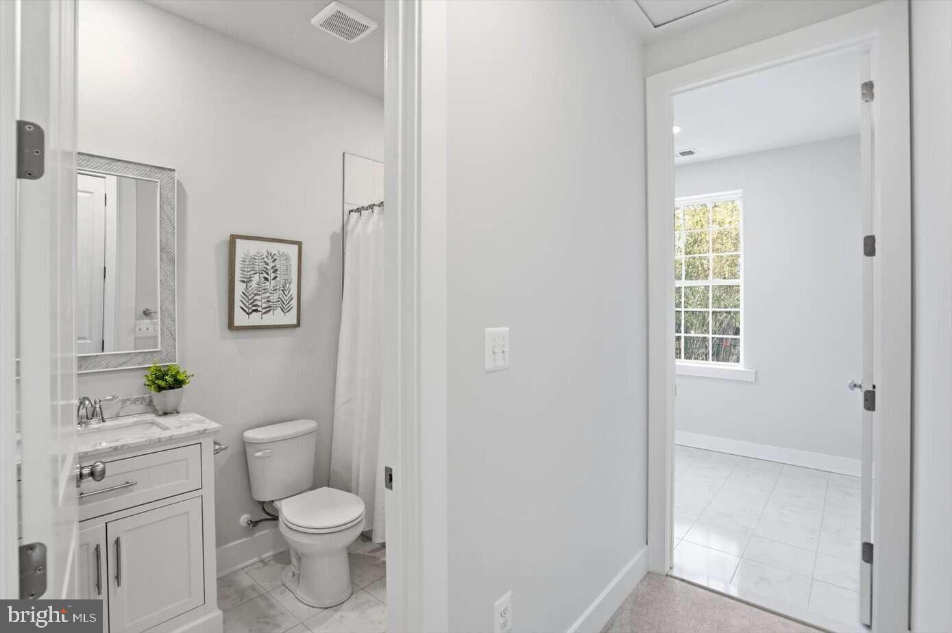 533 Forest View Road Linthicum Heights, MD 21090 - Photo 6 of 20 a bathroom with a granite countertop toilet a sink and a window