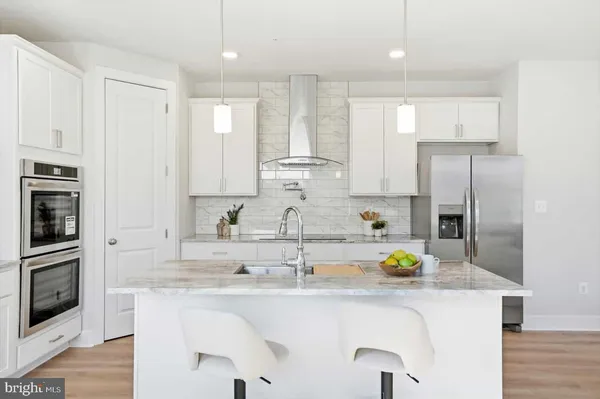 a kitchen with stainless steel appliances granite countertop a sink a refrigerator a counter space and cabinets