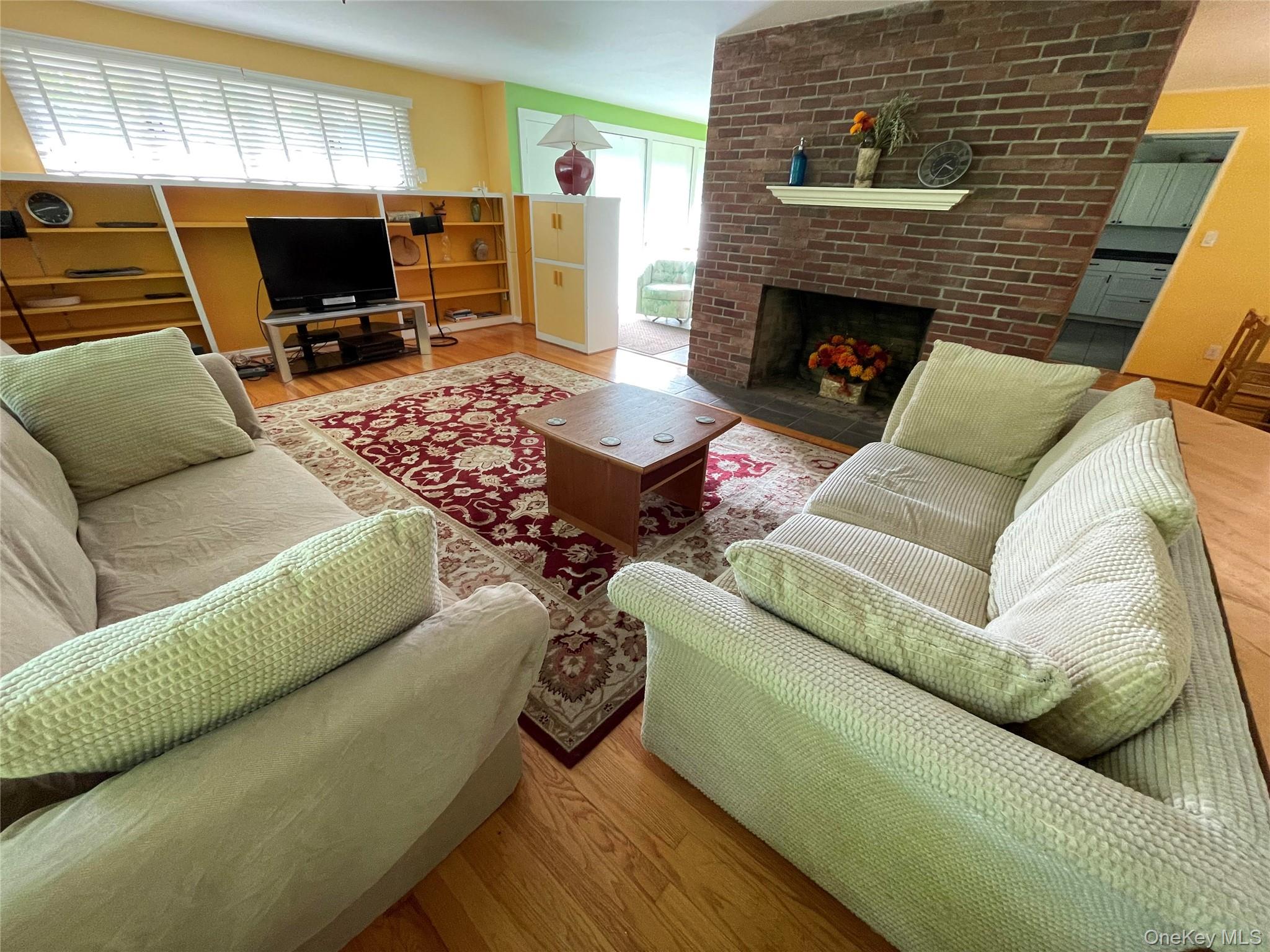 419 Triphammer Road Ithaca, NY 14850 - Photo 7 of 26 a living room with furniture a flat screen tv and a fireplace