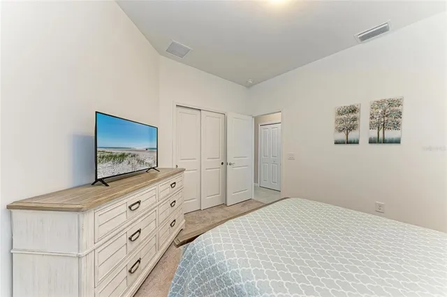 a large white kitchen with kitchen island a large counter space a sink stainless steel appliances and cabinets
