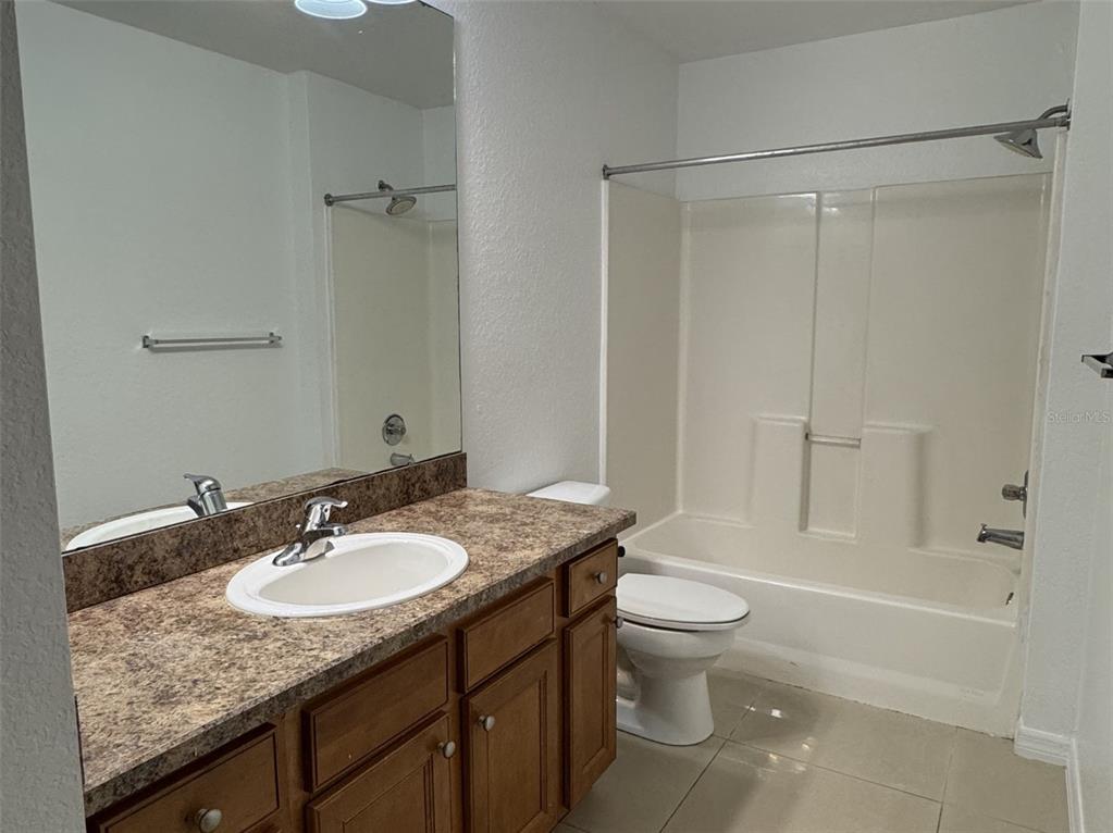 5483 Vineland Road, Unit 10201 Orlando, FL 32811 - Photo 13 of 35 a bathroom with a granite countertop sink toilet and shower
