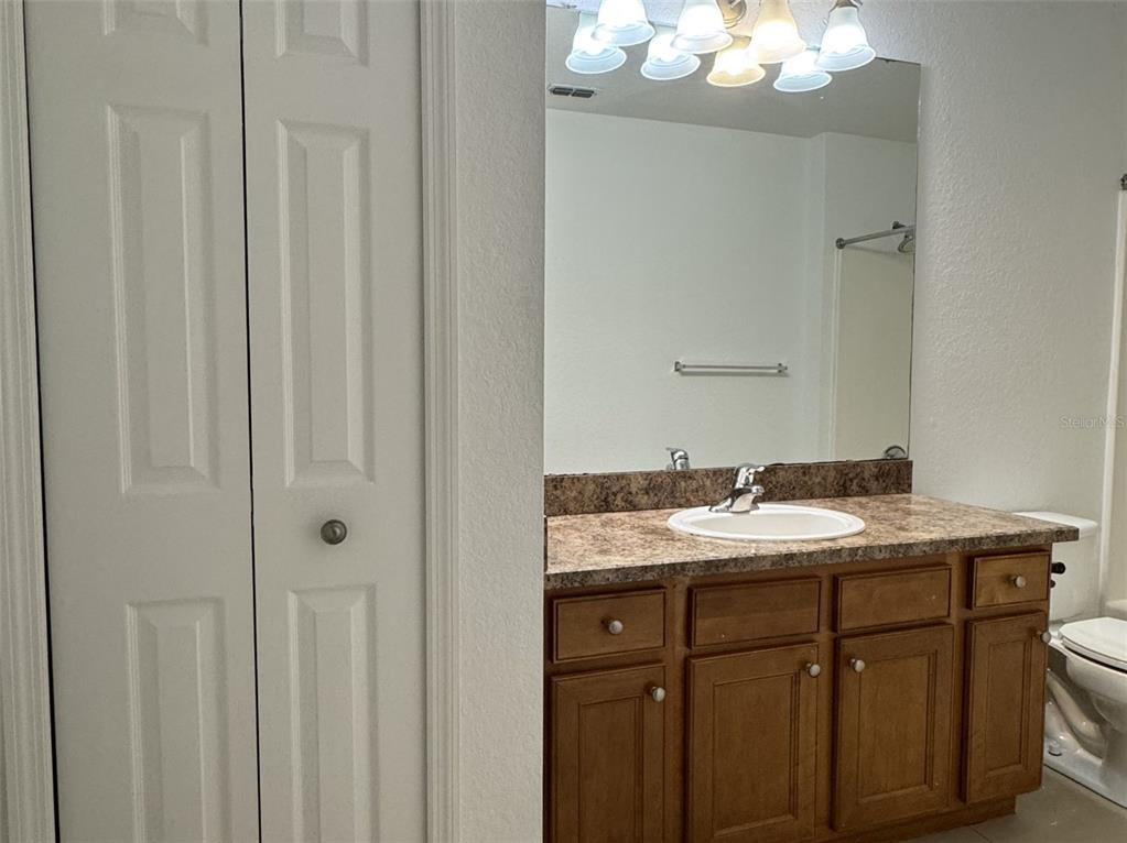 5483 Vineland Road, Unit 10201 Orlando, FL 32811 - Photo 14 of 35 a bathroom with a granite countertop sink and a mirror