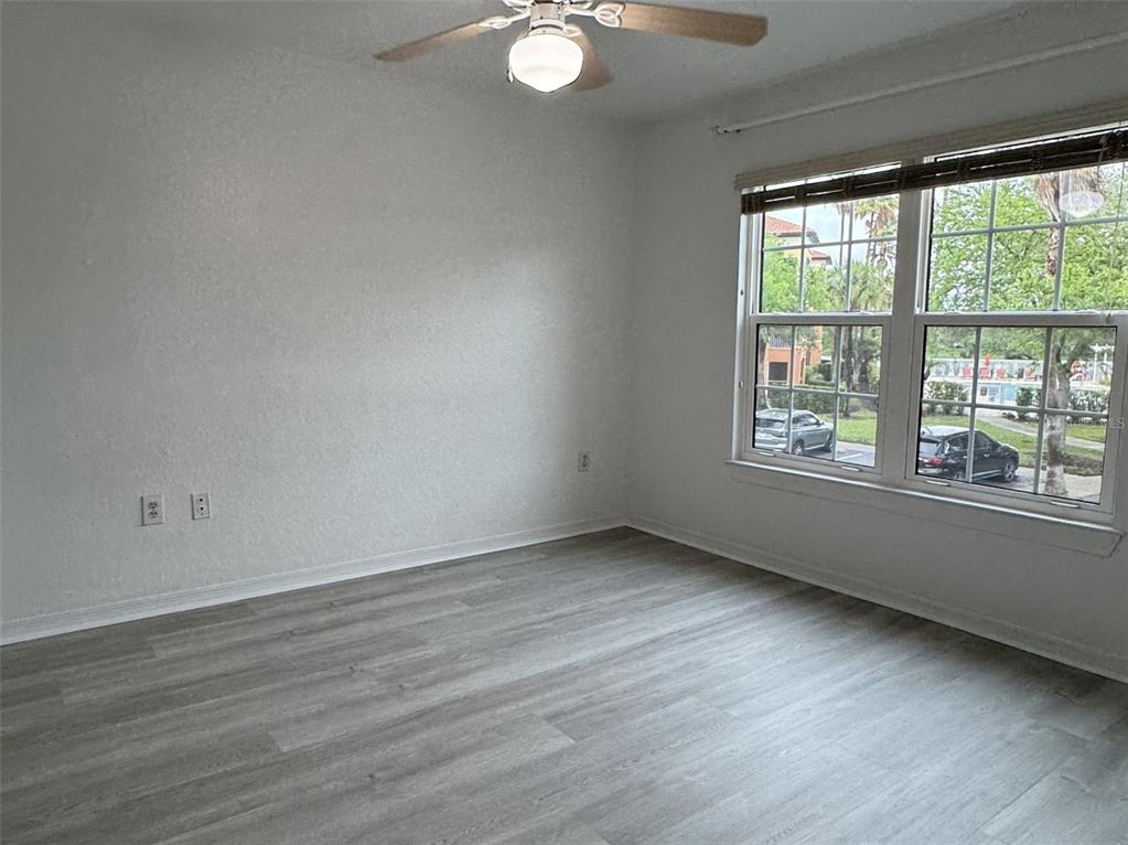 5483 Vineland Road, Unit 10201 Orlando, FL 32811 - Photo 16 of 35 an empty room with wooden floor and windows