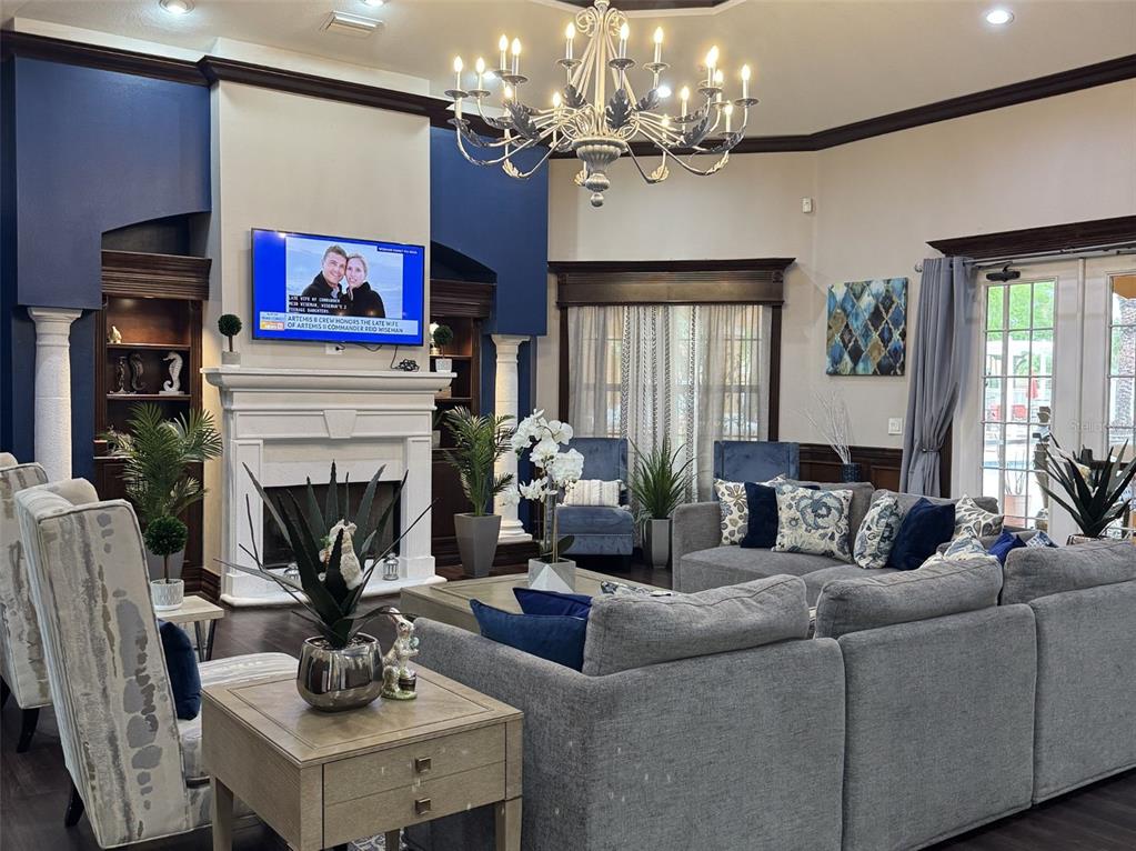 5483 Vineland Road, Unit 10201 Orlando, FL 32811 - Photo 28 of 35 a living room with furniture a fireplace and a chandelier
