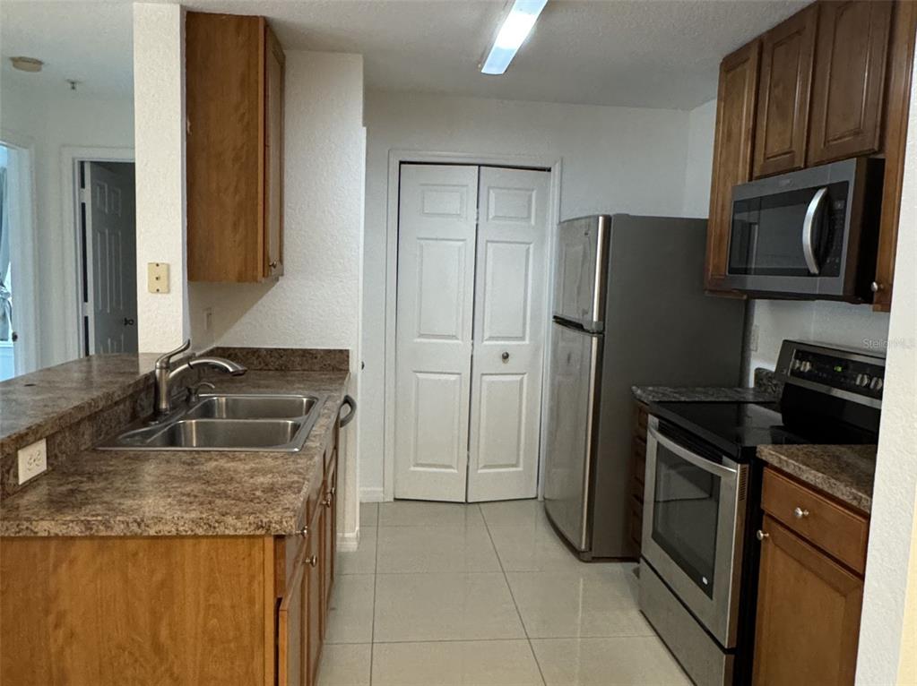 5483 Vineland Road, Unit 10201 Orlando, FL 32811 - Photo 6 of 35 a kitchen with granite countertop a refrigerator and a sink