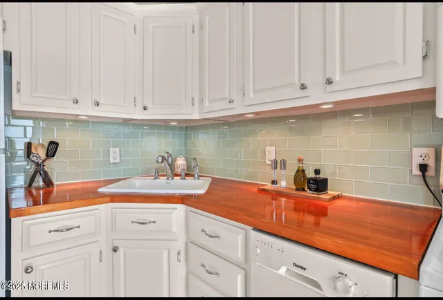 a kitchen with white cabinets and sink