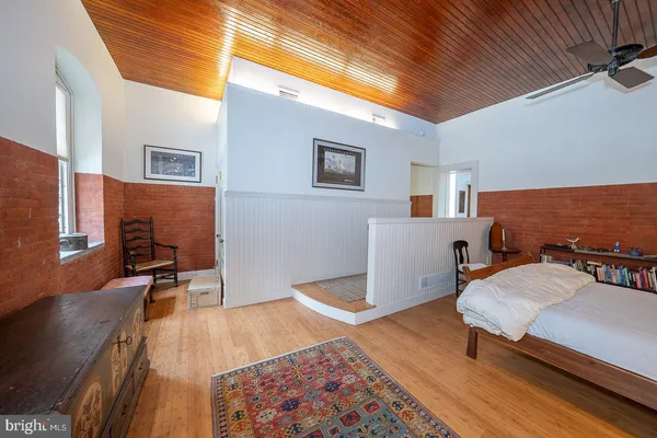 a living room with furniture dining table wooden floor and a flat screen tv