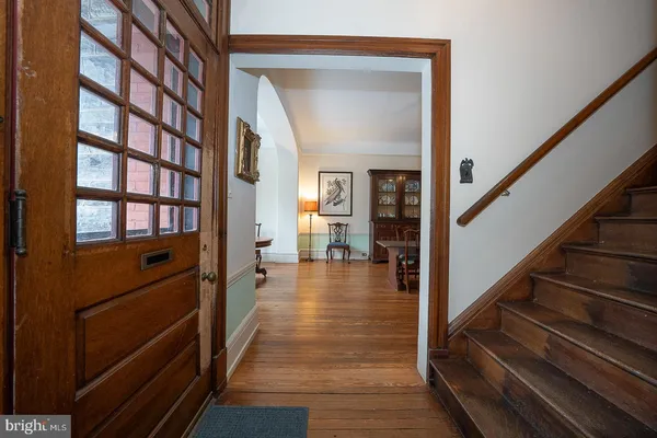 a view of a hallway with wooden floor and staircase