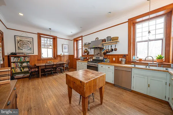 a bedroom with a bed a dresser and wooden floor
