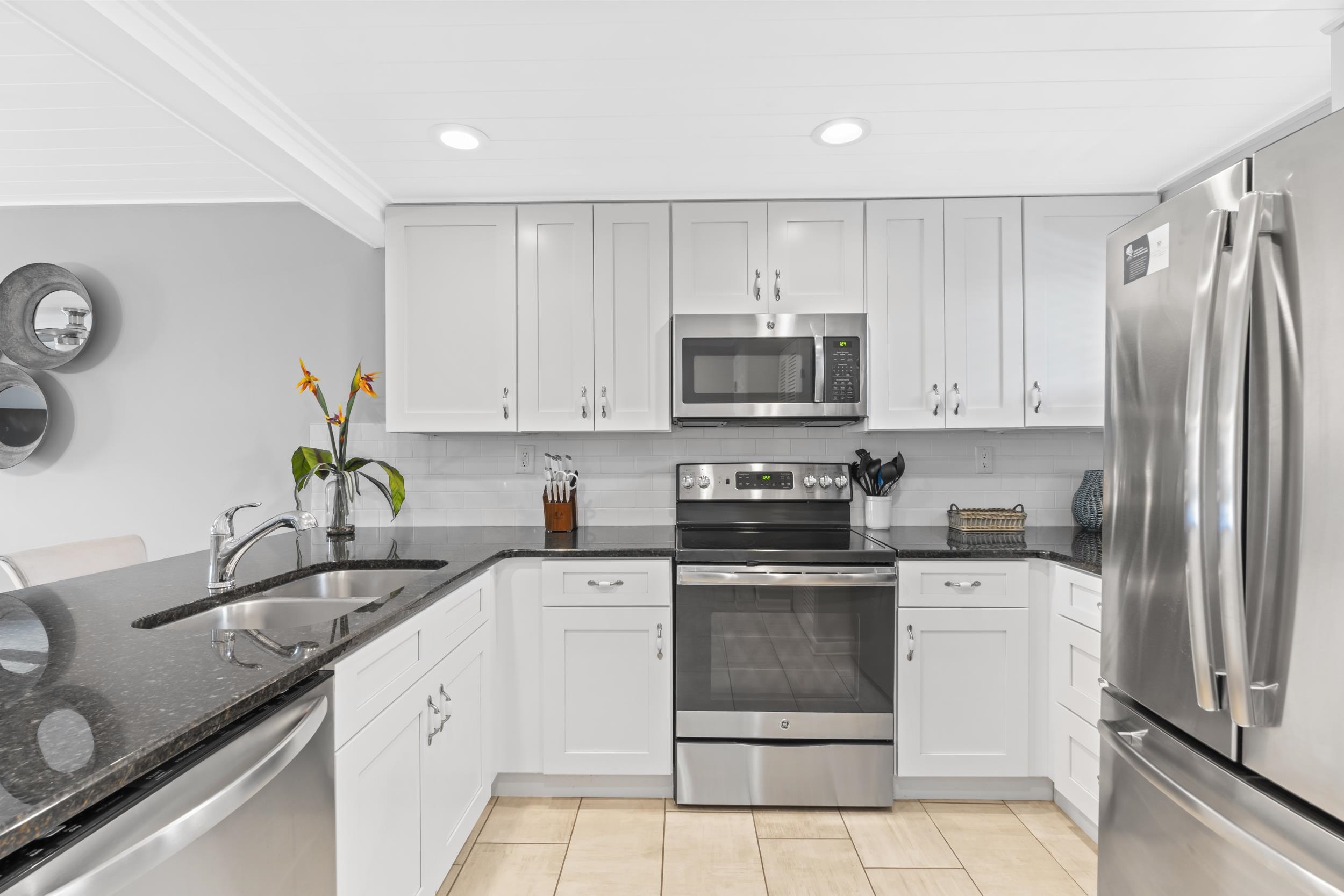 4250 A1A South, Unit P33 St. Augustine, FL 32080 - Photo 8 of 39 a kitchen with kitchen island a sink stainless steel appliances and white cabinets