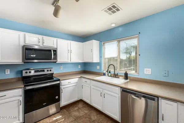 a kitchen with a sink a stove and cabinets