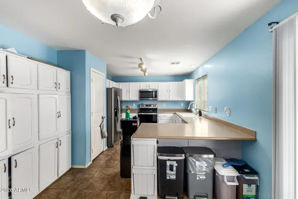 a kitchen with stainless steel appliances a sink cabinets and wooden floor