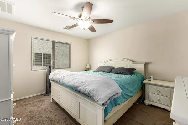a bedroom with a bed and a large window