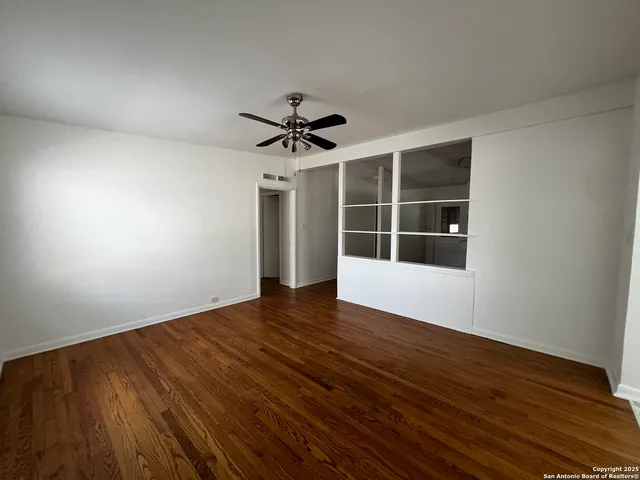 a view of room with wooden floor and ceiling fan