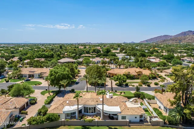 an aerial view of a house with a garden and lake view