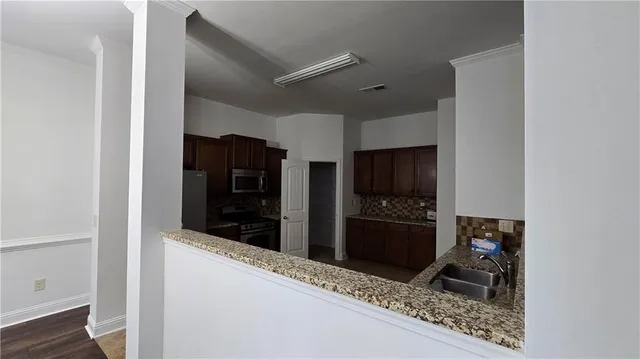 a kitchen with stainless steel appliances granite countertop a refrigerator and a stove