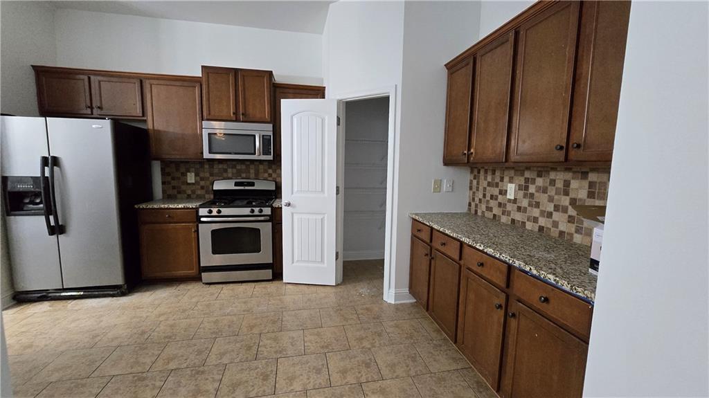 2275 Copper Trail Lane Northeast Buford, GA 30519 - Photo 2 of 39 a kitchen with stainless steel appliances granite countertop a stove a refrigerator and a sink