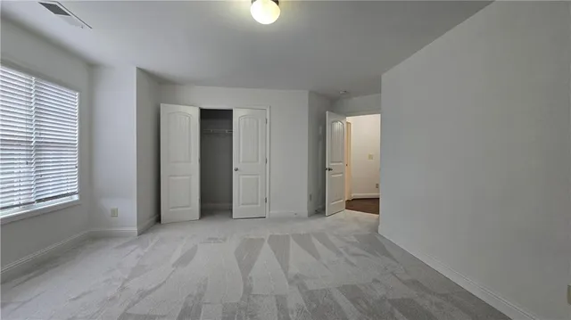 an empty room with window and hardwood floor