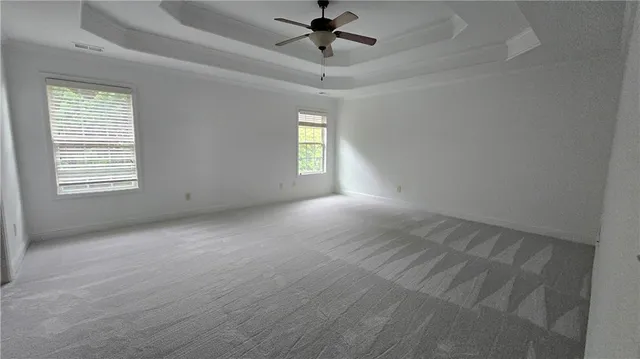 en empty room with windows and ceiling fan