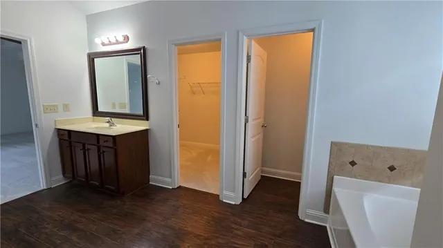 a view of a hallway with wooden floor and a cabinet