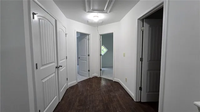 a view of a hallway with wooden floor and closet