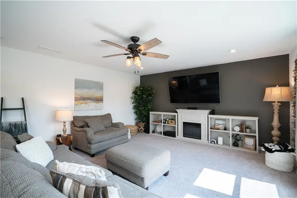 a living room with furniture a flat screen tv and a fireplace