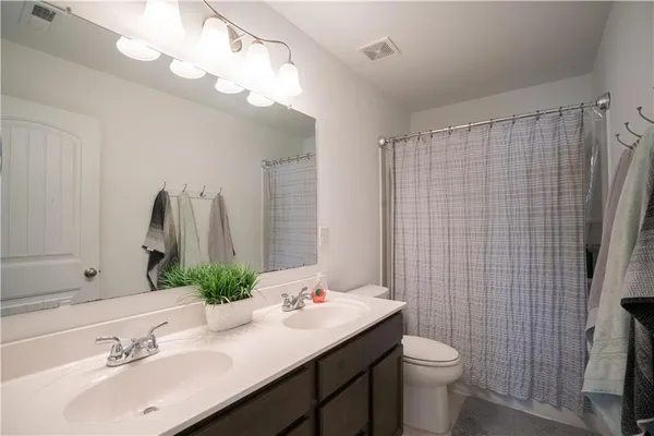 a bathroom with a sink vanity mirror and toilet