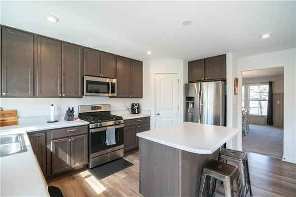 a kitchen with a sink a stove a refrigerator cabinets and a dining table