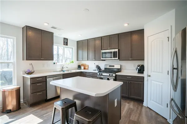 a kitchen with a sink a stove a refrigerator cabinets and furniture
