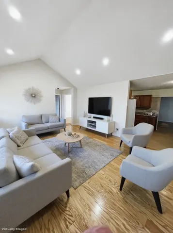 an empty room with a chandelier fan and windows