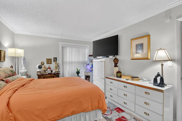 a bedroom with a bed and a flat tv screen on the dresser