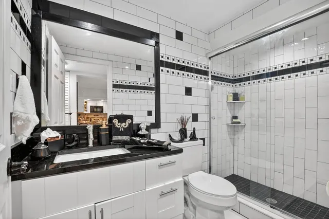 a bathroom with a double vanity sink toilet and shower