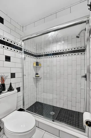 a bathroom with a toilet and a shower