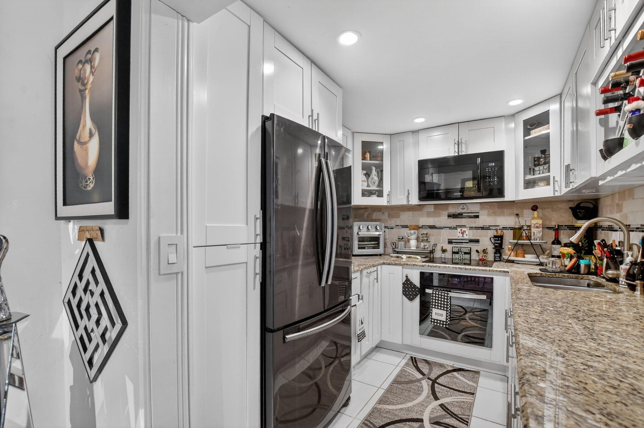 450 Northwest 20th Street, Unit 1140 Boca Raton, FL 33431 - Photo 6 of 29 a kitchen with stainless steel appliances granite countertop a refrigerator stove and microwave