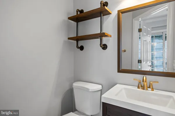 a bathroom with a sink a toilet and mirror