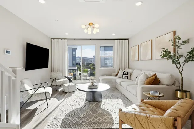 a living room with furniture a flat screen tv and a large window