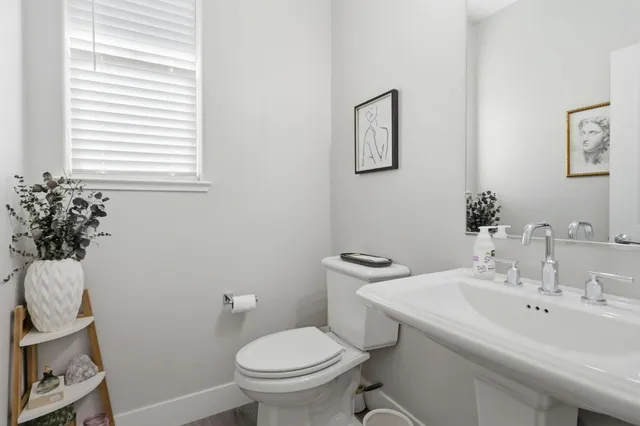 a bathroom with a sink toilet and a mirror
