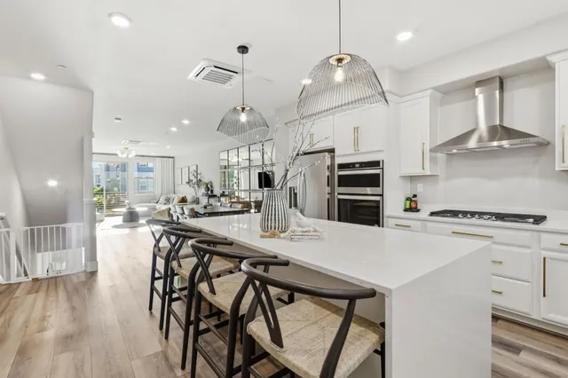 a kitchen with stainless steel appliances a stove a table a refrigerator and cabinets