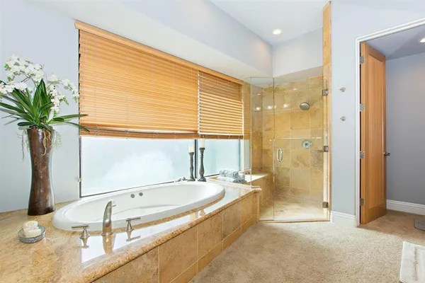 a spacious bathroom with a granite countertop tub sink and mirror