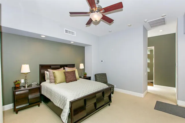 a large bedroom with a large bed and a flat tv screen
